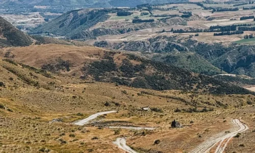 A female motorcyclist navigating a stunning off-road trail in Queenstown, part of the GOAT experience – an exclusive motorcycle tour for women led by experienced riders and supported by expert guides.